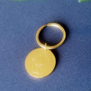 Lyklakippa með hjálparhönd Píeta grafna á 18 kt gullhúðaða plötu. Platan er 3 cm í þvermál og lyklakippan kostar 3.500 kr.
